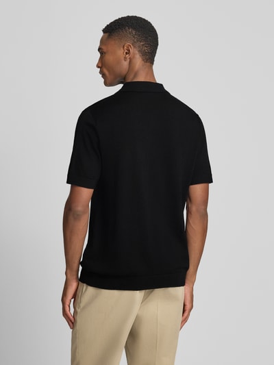 Männermodel trägt Regular Fit Poloshirt aus reiner Wolle Modell 'TRAY' von SELECTED HOMME, Optik: Unifarben, Strick, Ganzkörperansicht Rückansicht.