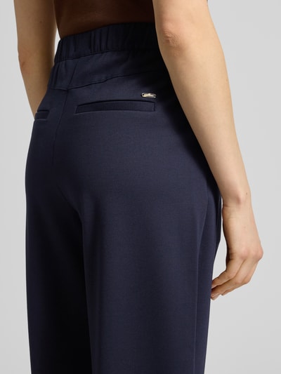 Frauenmodel trägt Barrel Fit Sweathose aus Viskose-Mix von s.Oliver RED LABEL in Optik: Unifarben, angedeutete Paspeltaschen, Nahaufnahme Rückansicht.