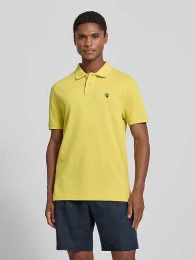 Męski model nosi Regular Fit Poloshirt mit Label-Stitching von MCNEAL z bawełny, listwa guzikowa, długość tyłu w rozmiarze M: 70 cm, kolor żółty, jasna faktura, krój regular fit, całkowity widok z przodu.