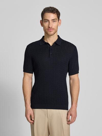 Męski model nosi Regular Fit Poloshirt aus reiner Baumwolle Modell 'ADRIAN-CA' von Strellson, dzianina w warkocze, krótki rękaw, kołnierzyk polo, dekolt w serek, listwa guzikowa, krój regular fit, czarna bawełna, imitacja dzianiny, Ganzkörperansicht von vorne.