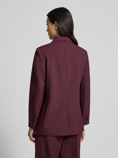 Vrouwenmodel draagt 'Relaxed Fit Kurzblazer aus Wollmix' van Tommy Hilfiger in effen bordeauxrood, relaxed fit, met 2-knoopsluiting, achteraanzicht hele lichaam.