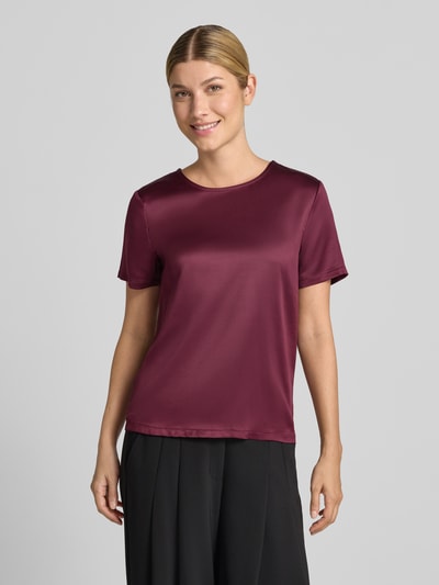Vrouwenmodel draagt Regular Fit Bluse aus Satin van Christian Berg Woman Selection in bordeauxrood satijn met ronde hals en korte mouwen, vooraanzicht bovenlichaam.