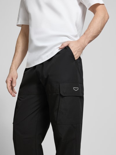 Männermodel trägt Regular Fit Hose mit Cargotaschen Modell 'LOGAN' von Antony Morato, Schwarz, Baumwoll-Mix, Nahaufnahme Oberschenkel.