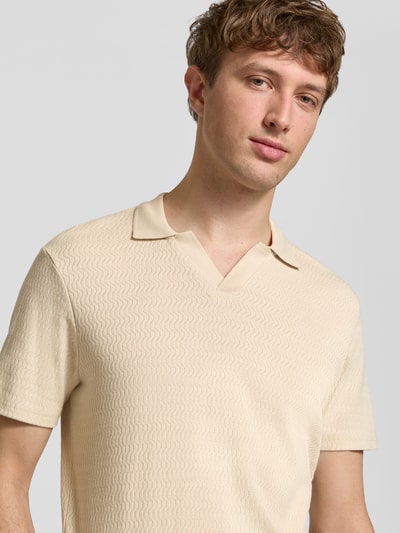 Mężczyzna nosi Regular Fit Polo-Shirt mit Strukturmuster Modell 'Heskild' von Blend z bawełny, krój regular fit, kołnierzyk polo, kremowy kolor, fakturowany wzór, koszulka z krótkim rękawem, długość tyłu w rozmiarze M: 69 cm, półzbliżenie klatki piersiowej z przodu.