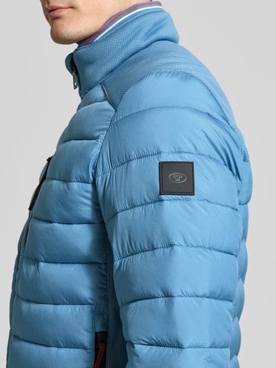 Männermodel trägt Regular Fit Steppjacke mit Stehkragen von Tom Tailor, Optik: Unifarben, Kontrastdetails, Nahaufnahme Oberkörper.