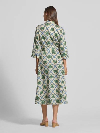 Frauenmodel trägt Hemdblusenkleid mit Bindegürtel und Knopfleiste von Christian Berg Woman in Creme mit grünem Palmenmuster, 3/4-Arm, reine Baumwolle, taillierter Schnitt, Midikleid, Ganzkörperansicht Rückansicht.