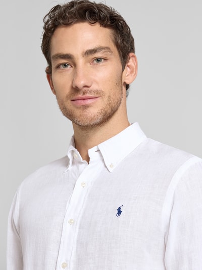 Męski model nosi Regular Fit Freizeithemd aus reinem Leinen od Polo Ralph Lauren, biała jednolita tkanina lniana, logo, zbliżenie na górę ciała.