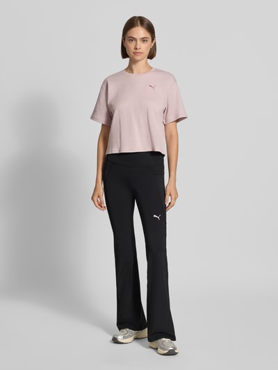 Frauenmodel trägt schwarze Slim Fit Sport-Leggings mit Logo-Print Modell 'TAD ESSENTIAL' von PUMA, Damen Sport-Leggings, Ganzkörperansicht von vorne.