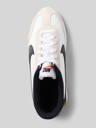 Produktfoto, Sneaker mit Label-Applikation Modell 'Pacific' von Nike in Weiß mit schwarzem Logo, abgerundete Form, Schnürverschluss, strukturierte Sohle, Absatzhöhe 2 cm, Schafthöhe 8 cm, Schaftweite 9 cm.