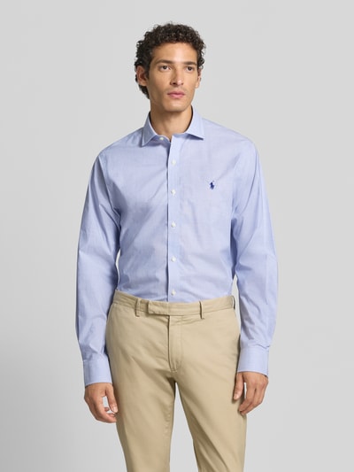 Männermodel trägt hellblaues Slim Fit Businesshemd aus reiner Baumwolle von Polo Ralph Lauren, glatte Textur, Ganzkörperansicht von vorne.