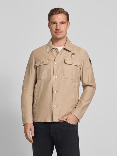 Męski model nosi Regular Fit Hemdjacke mit Brusttaschen Modell 'Goodale' od Blauer Usa w kolorze beżowym, z kieszeniami na piersi i kieszeniami bocznymi, czysta bawełna, długość tyłu 72 cm, szerokość ramion 52 cm, szerokość w rozmiarze M 55 cm, długość rękawa 68 cm, widok całej sylwetki z przodu.