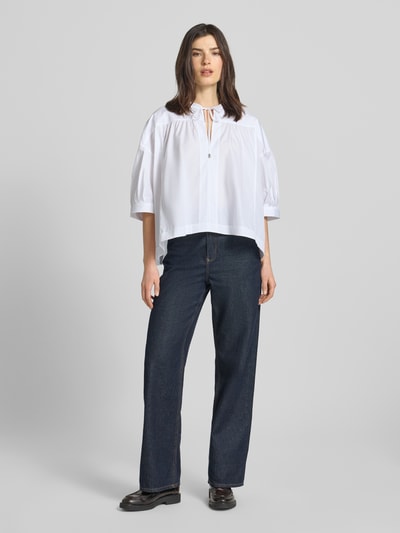 Frauenmodel trägt Oversized Bluse aus reiner Baumwolle Modell 'Bollana' von BOSS, Optik: Unifarben, Passform: Oversized, Kragenform: Tunika, Ausschnitt: Schlüsselloch, Verschluss: Knebelverschluss, Ärmelform: Kurzarm, Materialverarbeitung: Popeline, Material: reine Baumwolle, weiß, ganzkörperansicht von vorne.