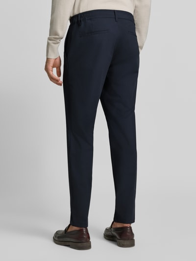 Männermodel trägt dunkelblaue Tapered Fit Stoffhose mit Viskose-Anteil Modell 'Phil' von Brax, glatte Oberfläche, Ganzkörperansicht Rückansicht, Herren Gerade Hose von Brax.