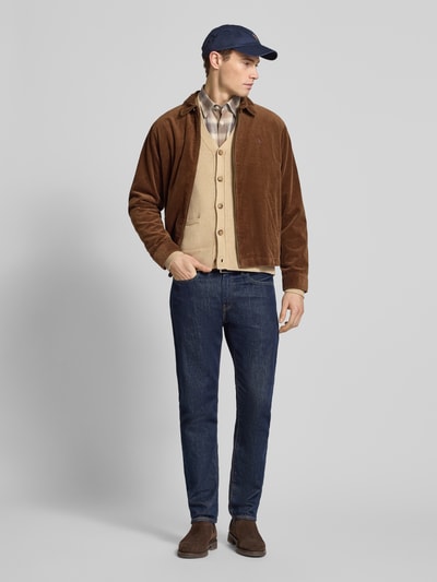 Männermodel trägt Regular Fit Strickjacke aus reiner Baumwolle von Polo Ralph Lauren, beżowy, gładki wzór, długi rękaw, widok całej sylwetki z przodu.