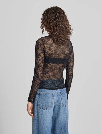 Frauenmodel trägt Longsleeve mit Cut Out von Gina Tricot in Schwarz, semitransparente Spitze, körpernah, Rückenansicht, Ganzkörperansicht Rückansicht