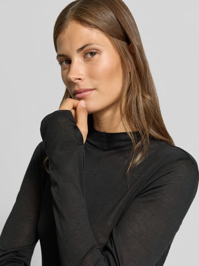 Frauenmodel trägt Longsleeve in semi-transparenter Optik von MYON, Lyocell-Mix mit Woll-Anteil, eng anliegend, Rollkragen, Nahaufnahme Oberkörper.