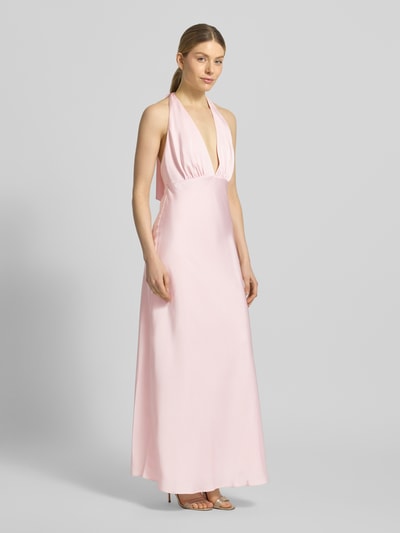 Modelka kobieca nosi długą, różową sukienkę satynową Maxikleid mit V-Ausschnitt Modell 'Dascha' od JOOP!, głęboki dekolt, wiązany neckholder, przylegający krój, rozciągliwa tekstura, tylny suwak, długość pleców w rozmiarze 36 to 137 cm, szerokość w rozmiarze 36 to 41 cm, widok całej sylwetki z przodu.