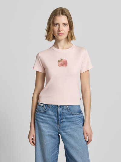 Frauenmodel trägt Regular Fit T-Shirt aus reiner Baumwolle von Levi's® in zartrosa mit Erdbeerprint, unifarben, Rundhals, Kurzarm, Ganzkörperansicht von vorne.