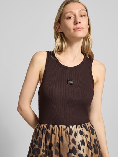 Frauenmodel trägt Midikleid mit Eingrifftaschen von Smith and Soul aus elastischem Baumwoll-Modal-Mix in Braun mit taillierter Passform, Nahaufnahme Oberkörper.