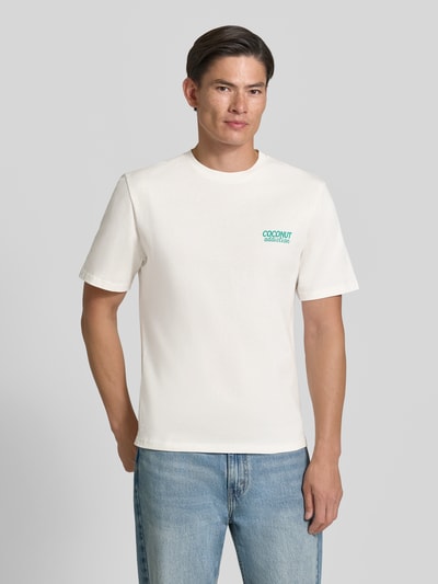 Männermodel trägt Relaxed Fit T-Shirt aus reiner Baumwolle von REVIEW in Offwhite mit grünem Motiv-Print, kurzärmelig, Nahaufnahme Oberkörper.