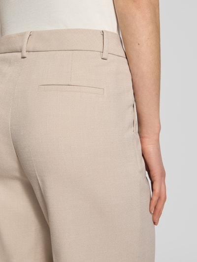 Frauenmodel trägt Hose mit Bügelfalten und Paspeltaschen am Gesäß von More & More, Material-Mix mit Viskose-Anteil, Detailaufnahme Rückansicht.