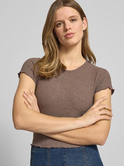 Kobiece model prezentuje Slim Fit T-Shirt mit Ripp-Struktur Modell 'EMMA' od Only, kolor jednolity, krój slim fit, okrągły dekolt, krótkie rękawy z falbanką, tekstura prążkowana, widok na górną część ciała z przodu.