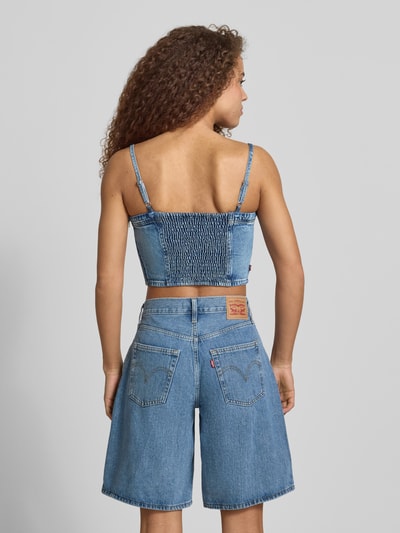 Młodzieżowy modelka nosi Slim Fit Crop Top aus reiner Baumwolle Modell 'JADINE' od Levi's®, niebieski denim, label, ozdobne szwy, karczek, regulowane ramiączka spaghetti, bez rękawów, sesja: całopostaciowa z tyłu.