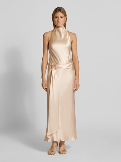 Vrouwenmodel draagt het 'Abendkleid mit Neckholder Modell Abby' van Forever New, satijn, aansluitende fit, maxijurk, beige, halslijn met knoopsluiting, diepe open rug, vooraanzicht gehele lichaam.