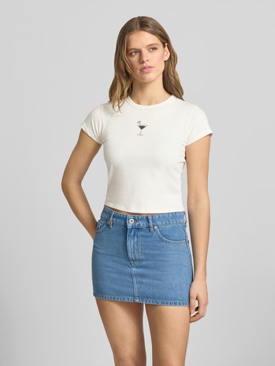 Frauenmodel trägt Slim Fit Damen T-Shirt aus reiner Baumwolle Modell 'DICHROMA_B' von Hugo Blue, Optik: Unifarben, Motiv-Print vorn, Rundhals, Kurzarm, Materialverarbeitung: Jersey, Farbe Weiß, Ganzkörperansicht von vorne.