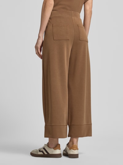 Männermodel trägt Sweatpants mit elastischem Bund von Rich & Royal, modal z domieszką stretchu, krój wide fit, kieszenie z tyłu, długość wewnętrzna nogawki w rozmiarze S: 66 cm, widok całej sylwetki z tyłu.
