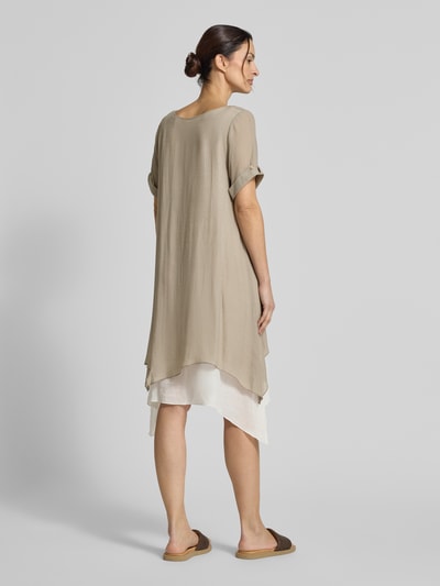 Modelka nosi Knielanges Kleid aus Viskose-Mix od Apricot, beżowy kolor, prosty krój, długość do kolan, okrągły dekolt, rękawy z mankietem, długość pleców w rozmiarze S: 94 cm, szerokość w rozmiarze S: 49 cm, długość rękawa w rozmiarze S: 22 cm, widok całej sylwetki z tyłu.