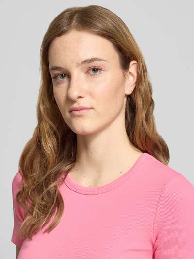 Frauenmodel trägt T-Shirt mit geripptem Rundhalsausschnitt Modell 'FRANKIE' von JJXX, pink, feine Rippenstruktur, Nahaufnahme Oberkörper.