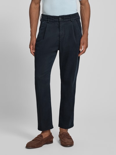 Męski model nosi spodnie Regular Fit Hose mit Eingrifftaschen Modell 'CHASY' von DRYKORN, mieszanka lyocellu i bawełny, ciemnoniebieskie, wpuszczane kieszenie, krój regular fit, szerokość w rozmiarze 32/32: 41 cm, długość wewnętrzna nogawki: 71 cm, widok z przodu na całe ciało.