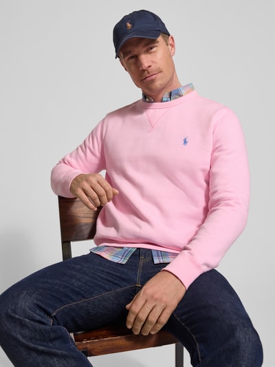 Männermodel trägt Regular Fit Sweatshirt aus katoenmix van Polo Ralph Lauren in effen roze met logodetail, ronde hals en geribde boorden, sweatmateriaal, Ganzkörperansicht von vorne.