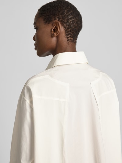 Frauenmodel trägt Regular Fit Hemdbluse aus Baumwolle von MM6 Maison Margiela in Weiß mit Hemdblusenkragen, Langärmelig, Rückenansicht, Detailaufnahme.