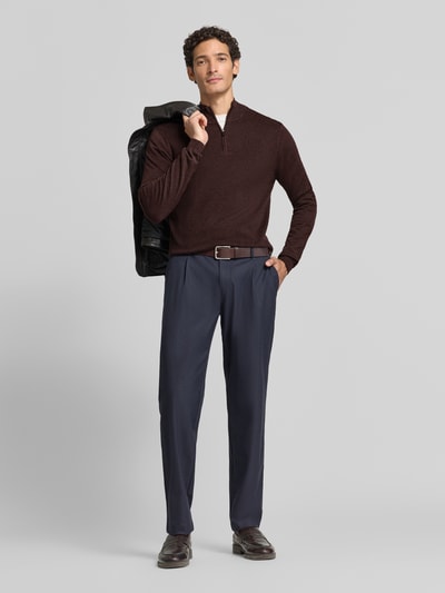 Mężczyzna nosi Slim Fit Strickpullover aus Baumwoll-Mix mit Viskose-Anteil od ROY ROBSON w kolorze ciemnego brązu, melanżowa faktura, design troyer z długimi rękawami, ściągacze, małe emblemat logo, spodnie granatowe, widoczna długość 69 cm i rękaw 72 cm w rozmiarze M, pełen widok sylwetki z przodu.