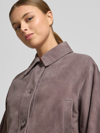 Kobiece modelka nosi Slim Fit Lederjacke aus echtem Ziegenleder Modell 'SADELA' von BOSS Orange, kolor jednolity, kołnierz wykładany, zapięcie na pojedynczy rząd guzików, długie rękawy, boczne kieszenie, wykonana z czystej skóry koziej, faktura welurowa, label stitching; ujęcie: zbliżenie na górną część ciała.
