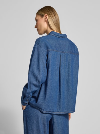 Vrouwenmodel draagt Regular fit jeanshemd met hemdblousekraag model 'ARCHER' van ICHI in effen blauw katoen, rugaanzicht, context: dames jeanshemd van ICHI, pure katoen, regular fit, model 'ARCHER', hemdblousekraag, knopenlijst, ruglengte maat 36: 62 cm, mouwlengte maat 36: 56 cm.