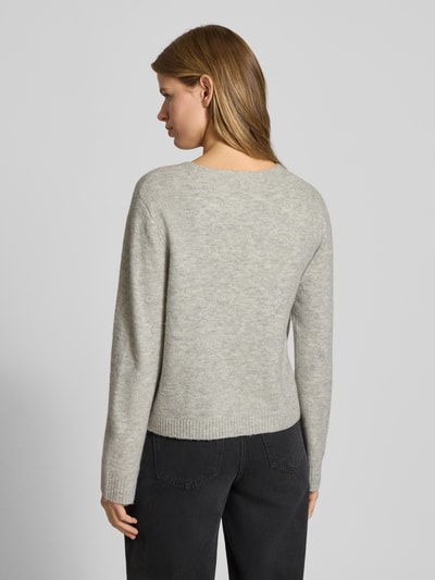 Frauenmodel trägt Oversized Strickjacke mit Woll-Anteil Modell 'RENE' von Only in Optik: Unifarben, Ganzkörperansicht Rückansicht.