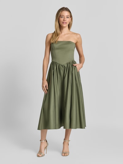 Modelka nosi sukienkę koktajlową im Off-Shoulder-Look mit Smok-Details von Jake*s Cocktail z mieszanki bawełny i elastanu, linia a, sukienka midi, odkryte ramiona, długość tyłu w rozmiarze 36: 104 cm, szerokość w rozmiarze 36: 35 cm, oliwkowy kolor, matowa tekstura, przód, całkowita sylwetka, Ganzkörperansicht von vorne.