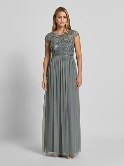 Frauenmodel trägt Abendkleid mit Pailletten von Christian Berg Cocktail, taliowany krój, okrągły dekolt, cekiny, obszycie ozdobnymi kamieniami, zamek błyskawiczny z tyłu, Długość tyłu w rozmiarze 36: 34 cm, Szerokość w rozmiarze 36: 40 cm, szara, długa, lejąca tkanina, Ganzkörperansicht von vorne