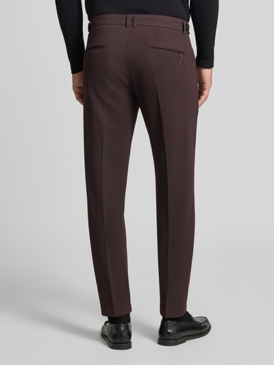 Männermodel trägt Straight Fit Hose mit Viskose-Mix Modell 'Salto' von CINQUE in Dunkelbraun mit Strukturmuster, Ganzkörperansicht Rückansicht. Elastischer Materialmix, Bügelfalten, Haken- und Reißverschluss, Bundweite 49 cm, Innenbeinlänge 74 cm.