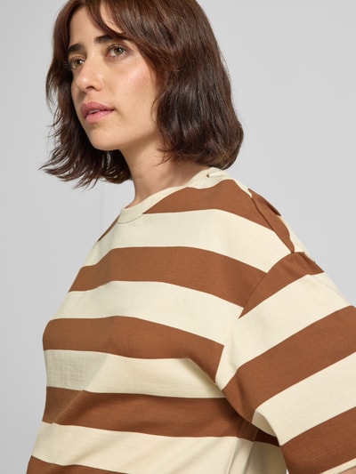 Frauenmodel trägt Oversized T-Shirt aus reiner Baumwolle von s.Oliver RED LABEL, breite braun-beige Streifen, Nahaufnahme Oberkörper.