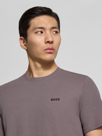 Männermodel trägt Regular Fit Pyjama-Oberteil aus Baumwoll-Mix Modell 'WAFFLE' von BOSS, unifarben, kurzarm, Nahaufnahme Oberkörper.
