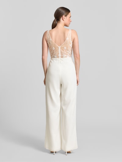 Modelka prezentuje Jumpsuit mit Spitze od Laona, kremowy kolor, koronkowy tył, krój slim fit, zapięcie na zamek, widok całej sylwetki z tyłu.