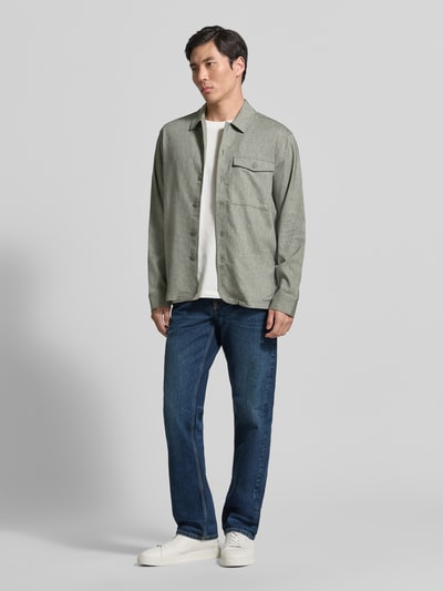 Męski model nosi Regular Fit Hemdjacke mit Kentkragen Modell 'BRO' von Casual Friday, mieszanka materiałów z domieszką lnu, krój regular fit, brustasza, długość tyłu w rozmiarze M: 71 cm, odcienie szarości, jeansy, białe buty, całopostaciowy widok z przodu.