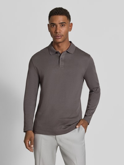 Männermodel trägt Regular Fit Poloshirt aus reiner Baumwolle von Christian Berg Men in Braun, langärmlig, glatte Struktur, Ganzkörperansicht von vorne.