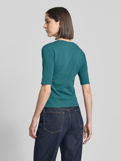 Frauenmodel trägt T-Shirt mit Rundhalsausschnitt von Christian Berg Woman, Baumwoll-Elasthan-Mix, Slim-Fit, 1/2-Arm, in Petrol, Rückenlänge 53 cm, Ganzkörperansicht Rückansicht
