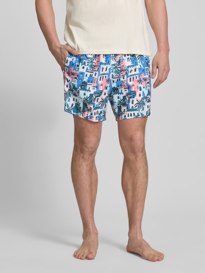 Männermodel trägt Badehose im Allover-Look Modell 'Vacay Villas' von BOARDIES, bunt, elastischer Bund, Kordelzug, Nahaufnahme Oberschenkel.