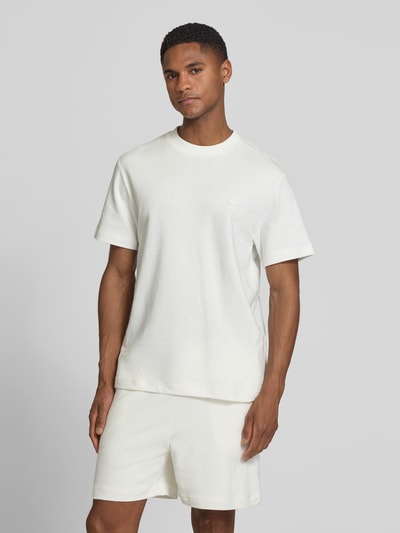 Männermodel trägt Regular Fit T-Shirt aus reiner Baumwolle von Lacoste, Optik: Unifarben, Label-Patch, Feinstrick, Rundhals, Kurzarm, Ganzkörperansicht von vorne.